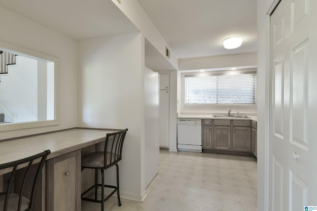 kitchen with a breakfast bar, dishwasher, and sink