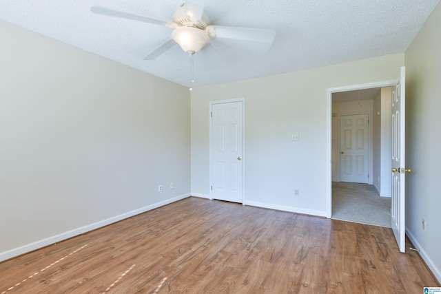 unfurnished bedroom featuring ceiling fan, a textured ceiling, and light hardwood / wood-style floors