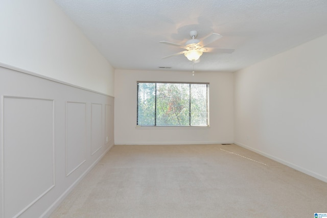 carpeted spare room with ceiling fan and a textured ceiling