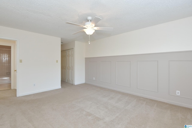 carpeted spare room with ceiling fan and a textured ceiling