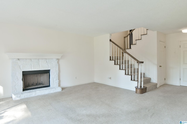 unfurnished living room featuring carpet and a stone fireplace