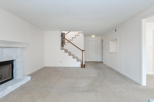 181 Cambrian Way Unit 181, Birmingham, AL 35242 - unfurnished living room featuring carpet flooring, stairs, a fireplace with raised hearth, baseboards, and a textured ceiling