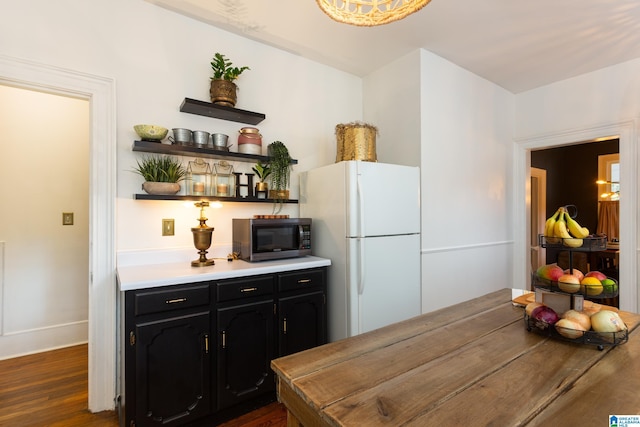 kitchen featuring white fridge and dark wood-type flooring