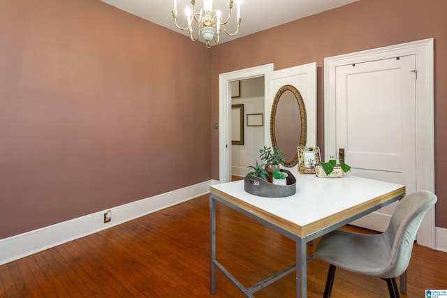 dining space with dark hardwood / wood-style floors and a notable chandelier