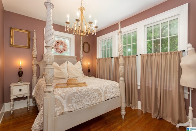 bedroom with a chandelier and dark wood-type flooring