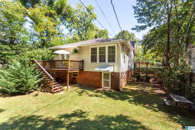 back of property with a yard and a deck