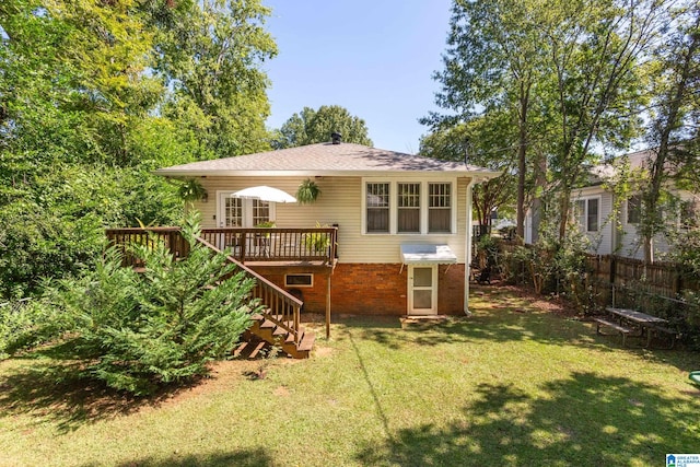 back of property with a yard and a wooden deck