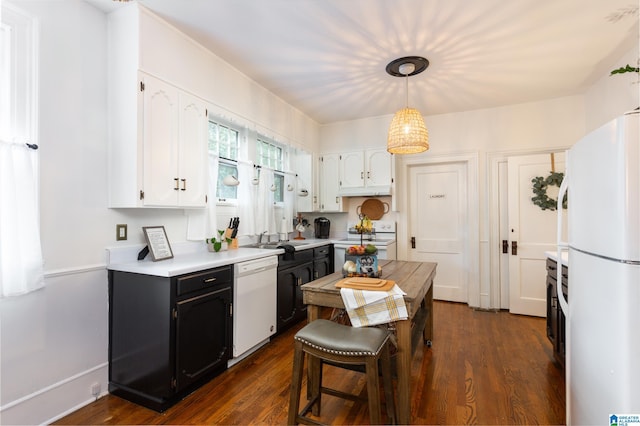 kitchen featuring white appliances, white cabinets, sink, dark hardwood / wood-style floors, and decorative light fixtures