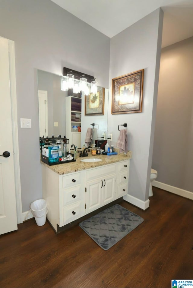 bathroom with hardwood / wood-style flooring, vanity, and toilet