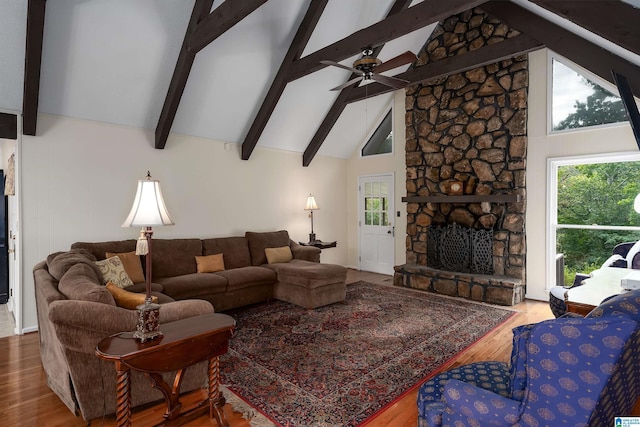 living room featuring wood-type flooring, beamed ceiling, a fireplace, and high vaulted ceiling