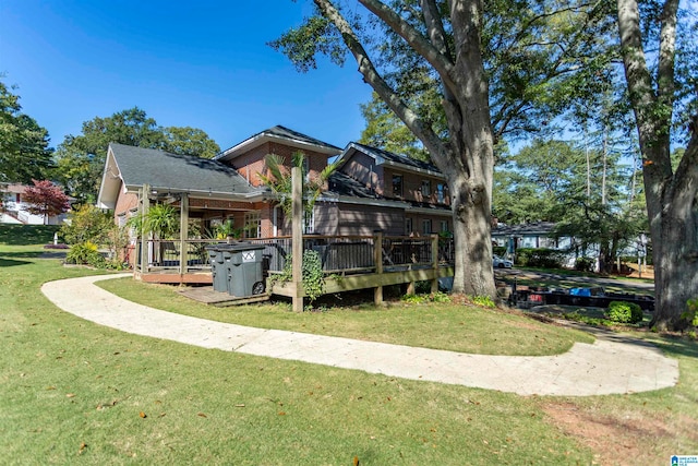 rear view of property featuring a deck and a lawn