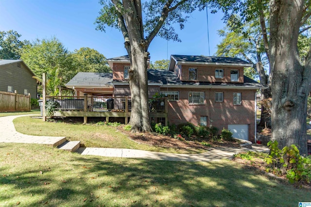 back of property with a wooden deck, a garage, and a lawn