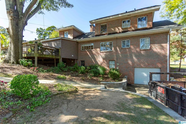 back of property with a wooden deck and a garage