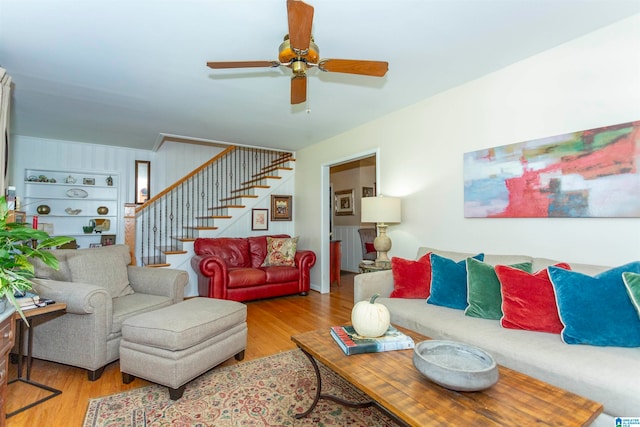 living room featuring ceiling fan, built in features, and light wood-type flooring