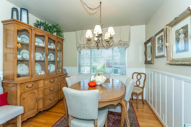 dining room with light hardwood / wood-style floors and an inviting chandelier