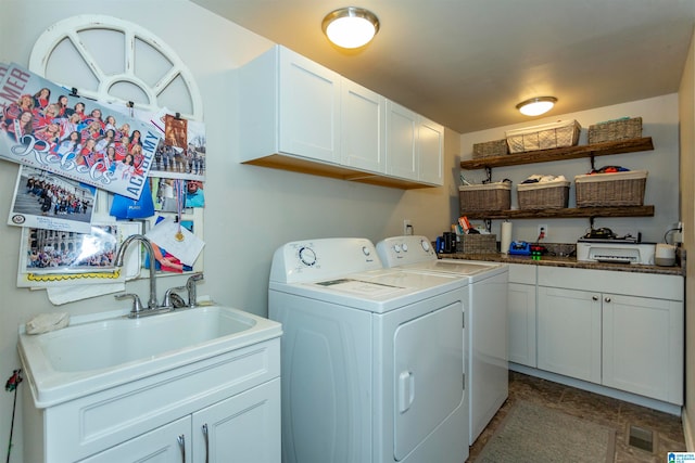 laundry room with sink, washing machine and dryer, and cabinets