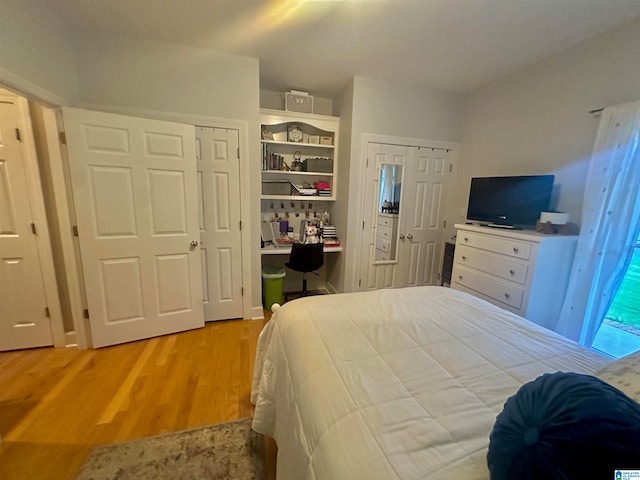 bedroom featuring built in desk and light hardwood / wood-style flooring