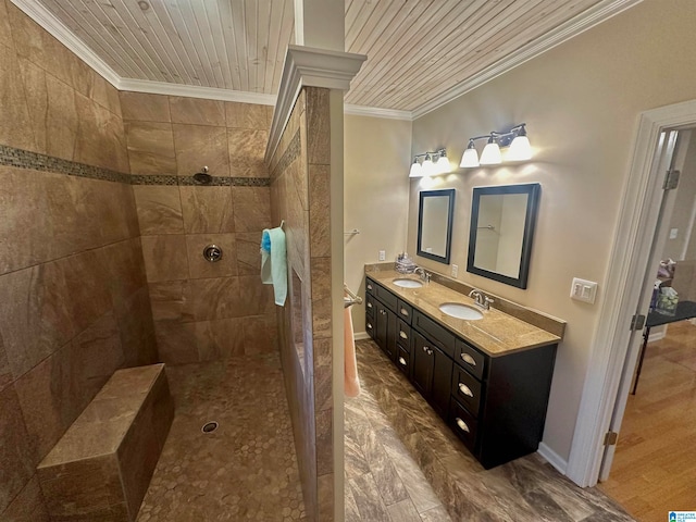 bathroom featuring a tile shower, wooden ceiling, ornamental molding, hardwood / wood-style flooring, and vanity