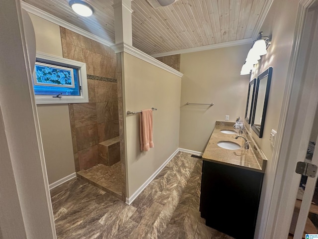 bathroom featuring a tile shower, crown molding, and vanity