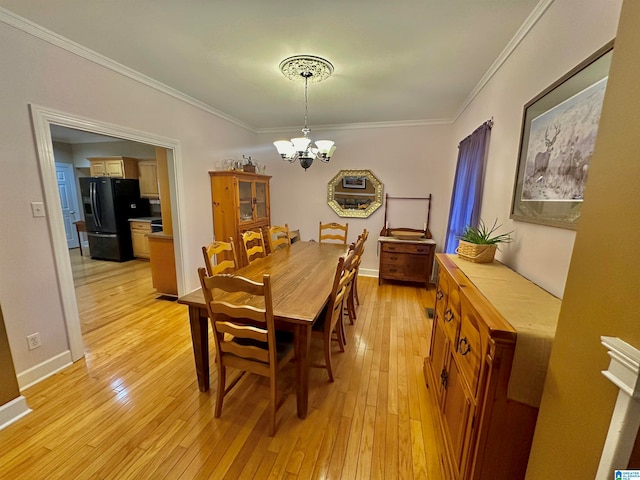 dining room with crown molding, a chandelier, and light hardwood / wood-style floors