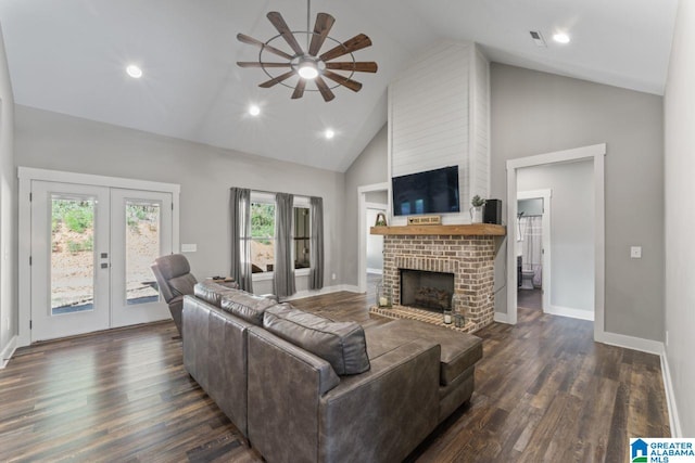 living room with ceiling fan, high vaulted ceiling, a brick fireplace, dark wood-type flooring, and french doors