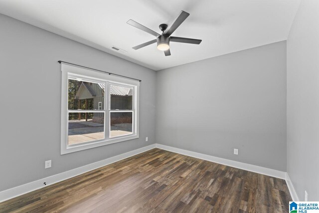 spare room featuring ceiling fan and dark hardwood / wood-style floors