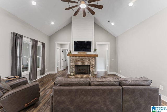 living room with ceiling fan, high vaulted ceiling, dark wood-type flooring, and a brick fireplace