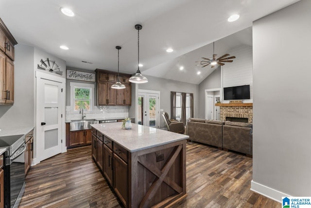 kitchen featuring french doors, dark hardwood / wood-style floors, stainless steel range with electric stovetop, sink, and a center island