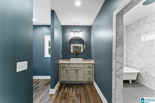 bathroom with vanity, hardwood / wood-style flooring, tile walls, and plus walk in shower