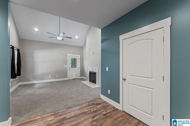 unfurnished living room with dark wood-type flooring, vaulted ceiling, and a high end fireplace