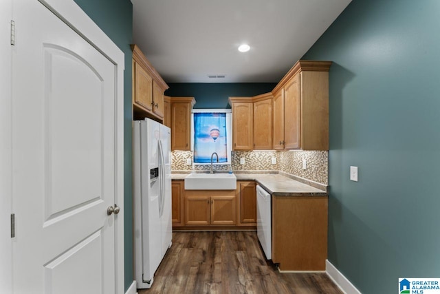 kitchen featuring white appliances, decorative backsplash, dark hardwood / wood-style flooring, and sink