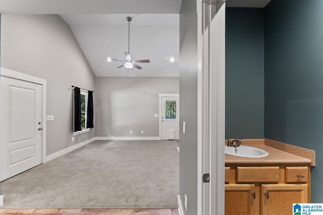 bathroom featuring a healthy amount of sunlight, sink, high vaulted ceiling, and ceiling fan