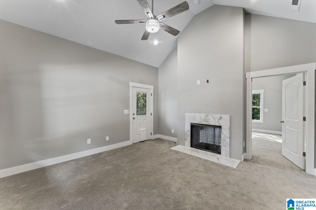 unfurnished living room with a premium fireplace, light carpet, high vaulted ceiling, and ceiling fan