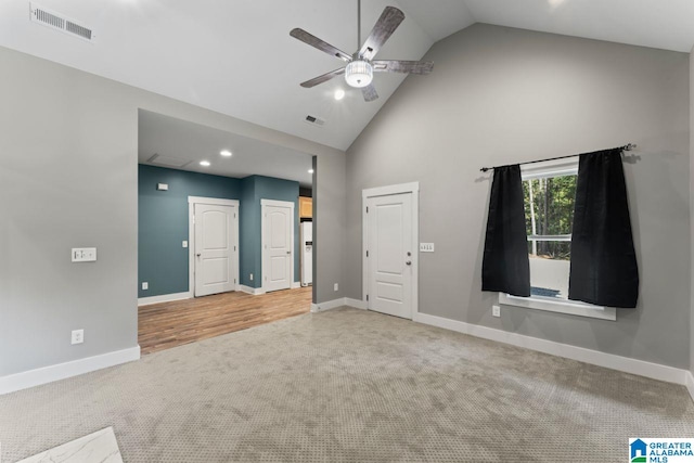 empty room with high vaulted ceiling, carpet, and ceiling fan