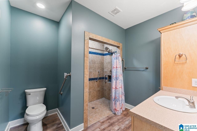 bathroom featuring vanity, a shower with shower curtain, hardwood / wood-style flooring, and toilet