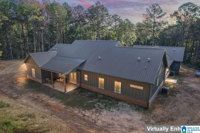 back house at dusk featuring central AC and a patio area