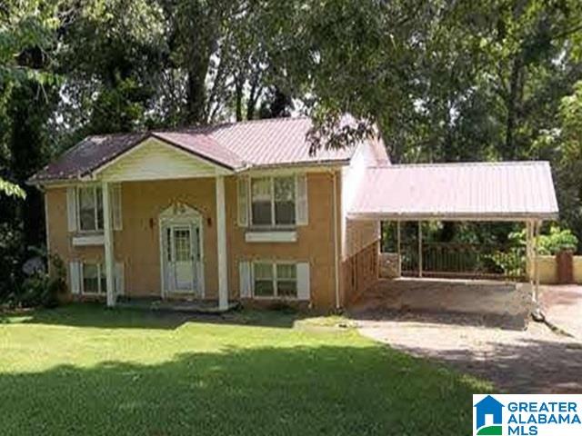 view of front of house with a front yard and a carport