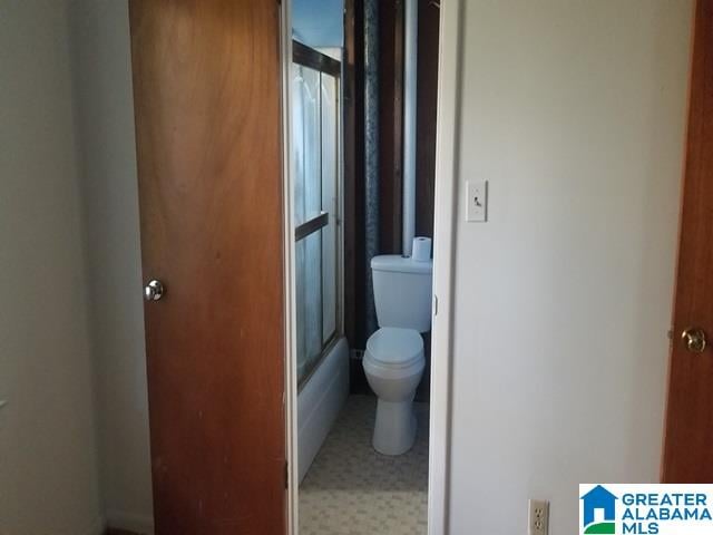 bathroom with toilet and enclosed tub / shower combo