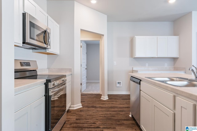 kitchen featuring dark hardwood / wood-style flooring, white cabinets, stainless steel appliances, and sink