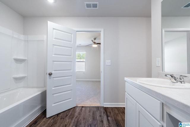 bathroom with bathing tub / shower combination, ceiling fan, vanity, and wood-type flooring