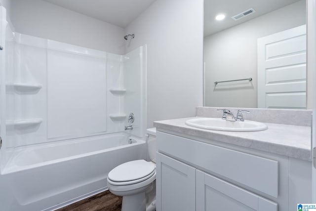 full bathroom with toilet, vanity, wood-type flooring, and washtub / shower combination