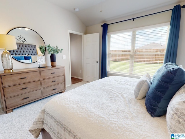 bedroom featuring light carpet and lofted ceiling