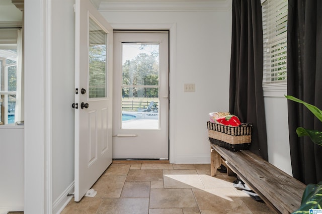 doorway with ornamental molding and a healthy amount of sunlight