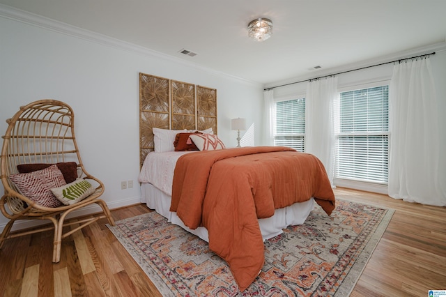 bedroom featuring light hardwood / wood-style floors and ornamental molding