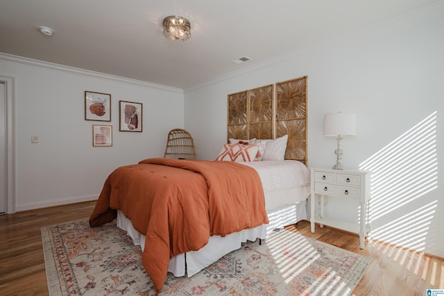 bedroom featuring light hardwood / wood-style flooring and crown molding