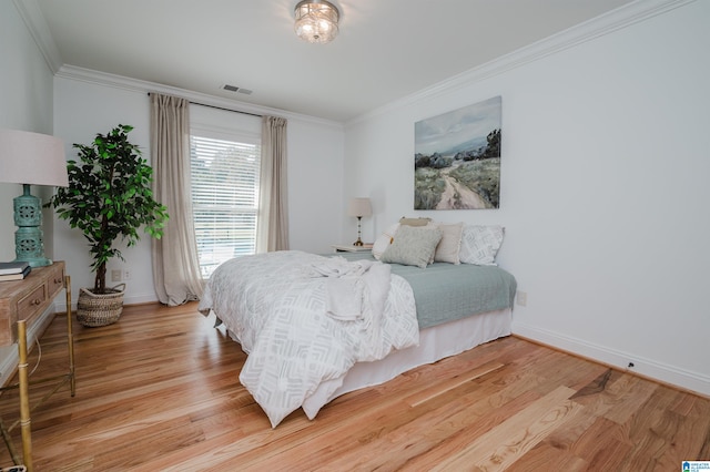 bedroom with light hardwood / wood-style floors and crown molding