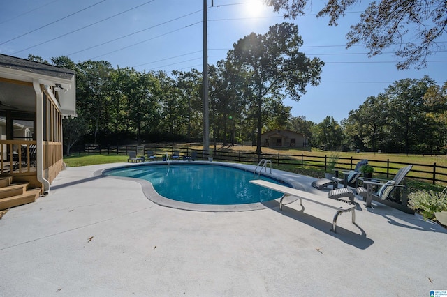 view of pool with a yard, a patio area, and a diving board