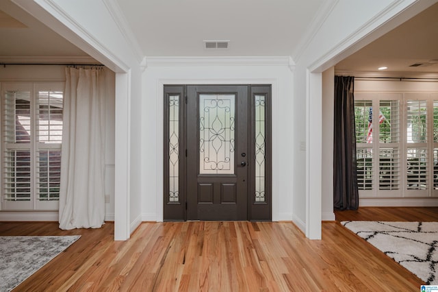 foyer with crown molding and light wood-type flooring