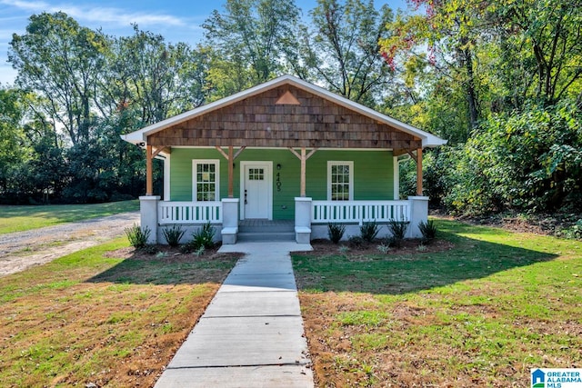 bungalow with covered porch and a front lawn