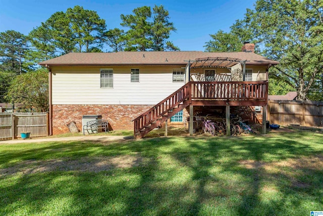 back of property featuring a wooden deck and a lawn